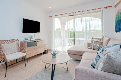 a living room with a couch and a tv at Palmas de Tamarindo 201D in Tamarindo