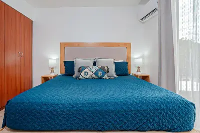 a bedroom with a blue bed with blue sheets and pillows at Palmas de Tamarindo 201D in Tamarindo