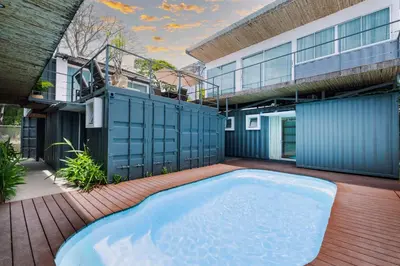 a swimming pool in the backyard of a house at Hotel Bamboo in Jacó