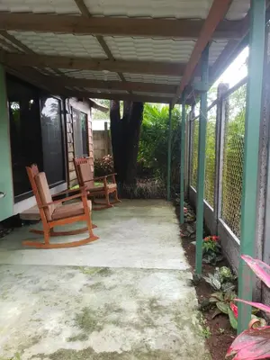 a porch of a house with two chairs at Cabaña Laurel in Fortuna