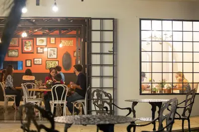 a group of people sitting at tables in a restaurant at Villa San Ignacio in Alajuela City