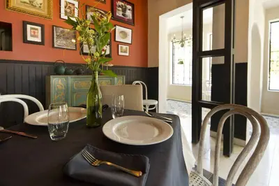 a dining room with a table with a vase of flowers at Villa San Ignacio in Alajuela City