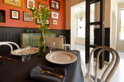 a dining room with a table with a vase with flowers at Villa San Ignacio in Alajuela City