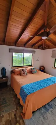 a bedroom with a large bed with a large window at Casa Garrobo in Laguna