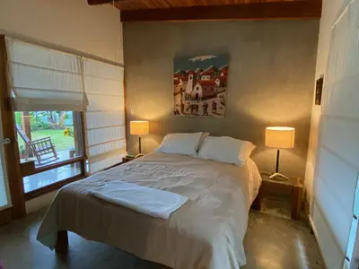 a bedroom with a bed with two lamps and a window at Casa Amanecer Bed & Breakfast in San Ramón