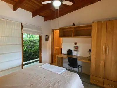 a bedroom with a bed and a desk at Casa Amanecer Bed & Breakfast in San Ramón