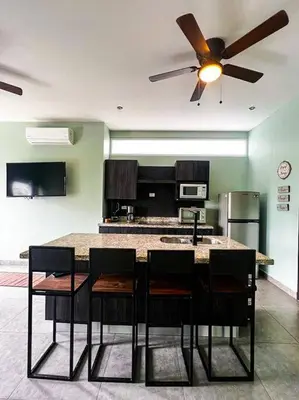 a kitchen with a table with chairs and a ceiling fan at Modern & convenient condo in Jaco downtown in Jacó