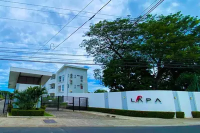 a white fence in front of a white building at Modern & convenient condo in Jaco downtown in Jacó