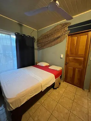 a bedroom with a bed and a wooden door at Surf House in Sámara
