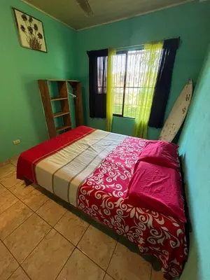 a bedroom with a bed and a surfboard in it at Surf House in Sámara