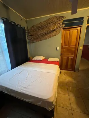 a bedroom with a bed and a wooden door at Surf House in Sámara