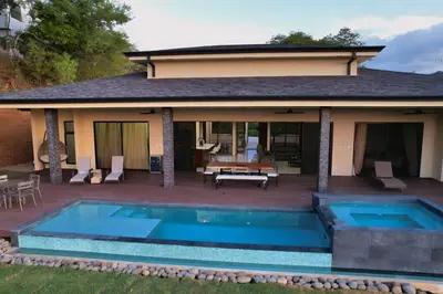 a house with a swimming pool and a patio at Casa Mon Coeur-Playa Del Coco Ocean View in Coco
