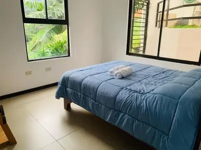 a bed with a towel on it in a bedroom at Casa mirando a la montaña, camino al volcán in Alajuela City