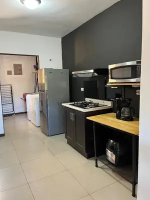 a kitchen with a stove and a refrigerator at Casa mirando a la montaña, camino al volcán in Alajuela City