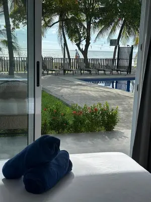 a blue pillow sitting on a bed in front of a window at BigWave Costa Rica in Playa Hermosa