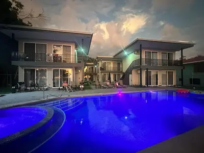 a house with a swimming pool at night at BigWave Costa Rica in Playa Hermosa