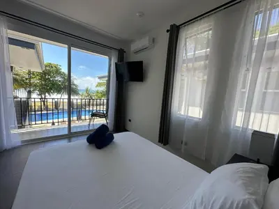 a bedroom with a bed and a large window at BigWave Costa Rica in Playa Hermosa