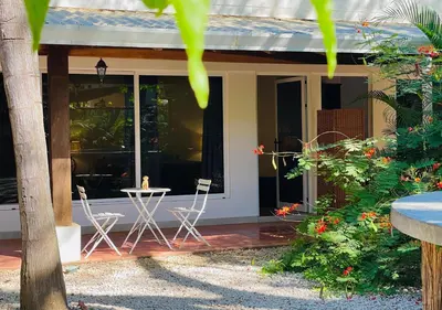 a house with two chairs and a table on a porch at Casa Spinoza in Playa Negra
