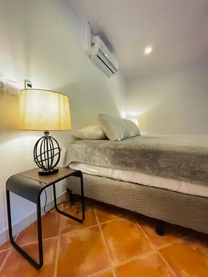 a bedroom with a bed and a table with a lamp at Casa Spinoza in Playa Negra