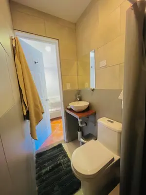 a bathroom with a white toilet and a sink at Casa Spinoza in Playa Negra