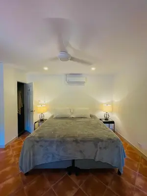 a bedroom with a large bed with two night stands at Casa Spinoza in Playa Negra
