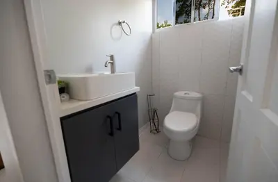 a white bathroom with a sink and a toilet at Beautiful modern house in Nandayure