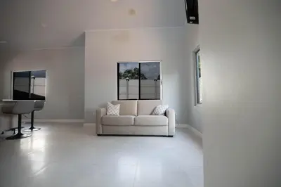 a white living room with a white couch and a piano at Beautiful modern house in Nandayure