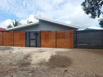 a house with a wooden fence in front of it at Beautiful modern house in Nandayure
