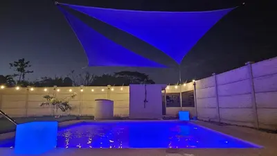 a swimming pool with blue lights on a fence at night at Beautiful modern house in Nandayure