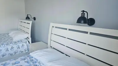 a bedroom with a bed and two lamps on the wall at Beautiful modern house in Nandayure