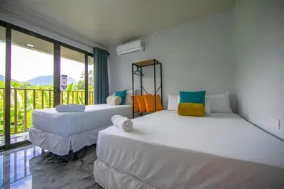 two beds in a room with a balcony at Villas Sapiens Arenal in Fortuna