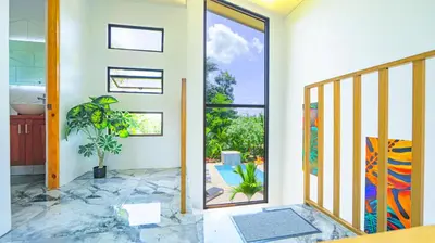 a hallway with a glass door leading to a patio at Villas Sapiens Arenal in Fortuna