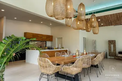 a dining room with a wooden table and chairs at Pandanus Lodge & Retreats Bungalow Gingiber in Cariblanco
