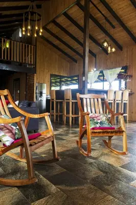 two wooden chairs in a room with a kitchen at La Casona de Los Santos in Cedral