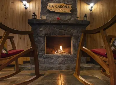 a fireplace in a room with two rocking chairs at La Casona de Los Santos in Cedral