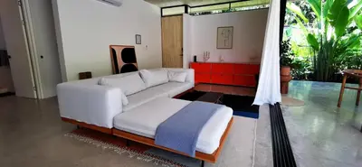 a living room with a white couch and a table at Casa Remy - Walk to the Beach and stay in a private compound! Pool, Kitchen, AC, Wi-Fi in Mal País