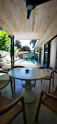 a living room with a table and chairs and a pool at Casa Remy - Walk to the Beach and stay in a private compound! Pool, Kitchen, AC, Wi-Fi in Mal País