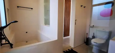 a bathroom with a toilet and a bath tub at Casa Remy - Walk to the Beach and stay in a private compound! Pool, Kitchen, AC, Wi-Fi in Mal País