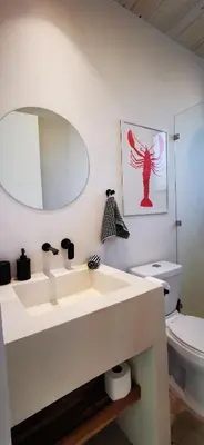 a bathroom with a white sink and a toilet at Casa Remy - Walk to the Beach and stay in a private compound! Pool, Kitchen, AC, Wi-Fi in Mal País