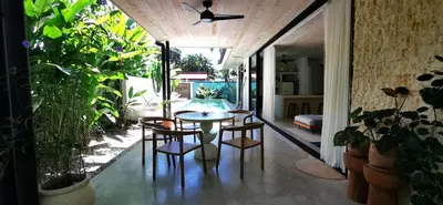 a table and chairs in a room with plants at Casa Remy - Walk to the Beach and stay in a private compound! Pool, Kitchen, AC, Wi-Fi in Mal País