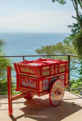 a red cart on display in front of a fence at SOL e MAR in Uvita