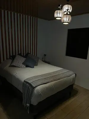 a bedroom with a bed and a chandelier at Serenity Mountain in Poás