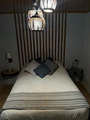a bedroom with a bed with two pillows and two lights at Serenity Mountain in Poás