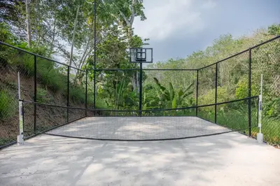 a basketball court with a basketball hoop on a fence at Vida Palace in Jacó