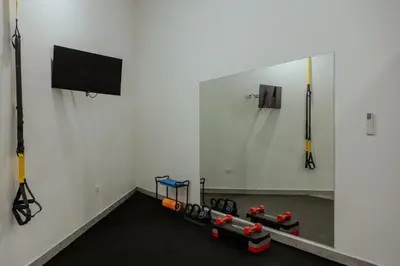 a room with a wall with a tv and some boxing equipment at Vida Palace in Jacó
