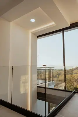 a room with glass walls and a balcony with a view at Vida Palace in Jacó