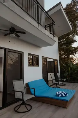 a bedroom with a bed and two chairs on a patio at Vida Palace in Jacó