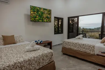 a bedroom with two beds and a balcony at Vida Palace in Jacó