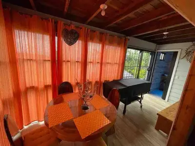 a dining room with a table and a piano at Parque Nacional Volcán Poás Cabaña Abby in Bajos Tigre