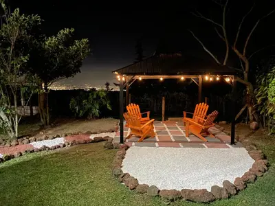 two orange chairs and a gazebo at night at Parque Nacional Volcán Poás Cabaña Abby in Bajos Tigre